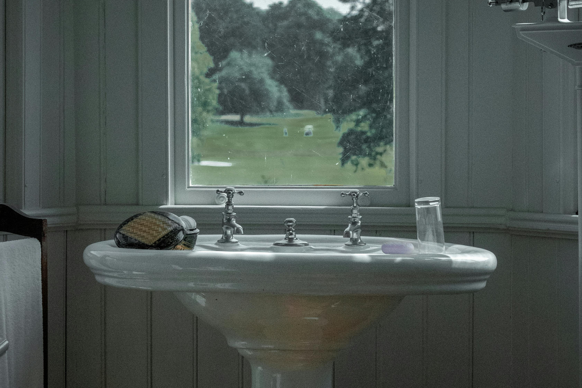 Lavatório de coluna clássico num ambiente de casa de banho com estilo vintage europeu e luz natural