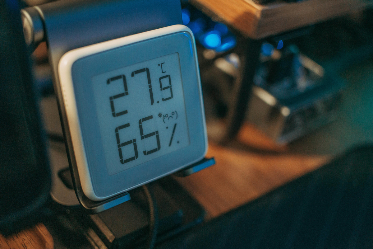 Higrómetro digital em cima de mesa a mostrar temperatura e humidade relativa